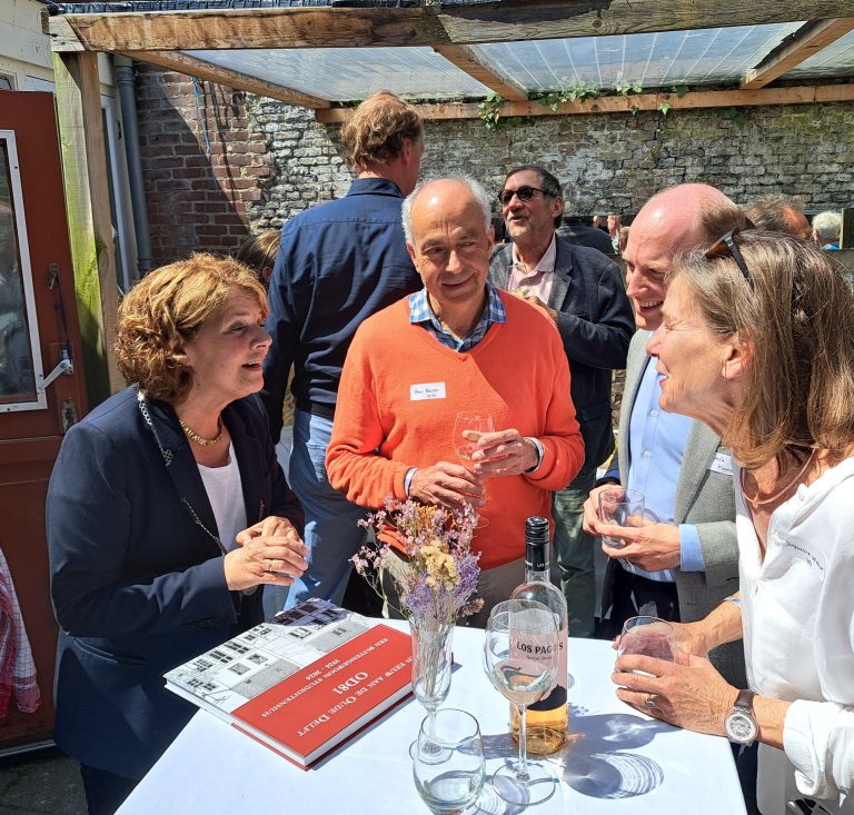 Burgemeester Marja van Bijsterveld praat met enkele genodigden op het feest.